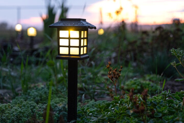 Solar-powered lanterns for flower beds in the yard of the house for decorative street lighting and landscaping