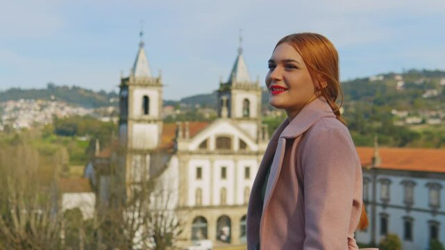 Stunning 4k footage of a young white caucasian ginger girl posing in front of the Abade Pedrosa Municipal Museum and the Monastery of St. Benedict (Sao Bento) in the Portugal city - Santo Tirso.