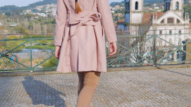 Stunning 4k footage of a young white caucasian ginger girl walking in front of the Abade Pedrosa Municipal Museum and the Monastery of St. Benedict (Sao Bento) in the Portugal city - Santo Tirso.