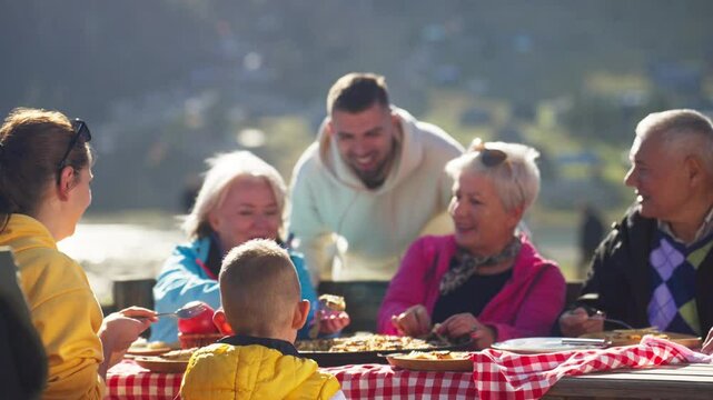 Caucasian Family Enjoying Traditional Turkish and Balkan Meal Borek by a Mountain Lake on a Sunny Day. Concept of Turkish Food, Lunch, Enjoying, Eating, Delicious, Gastronomy, Cuisine, Tasty, Savory