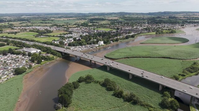 Aerial view of the M5 motorway outside of Exeter crossing over the River Exe, showcasing the integration of transportation infrastructure with the natural environment in the United Kingdom