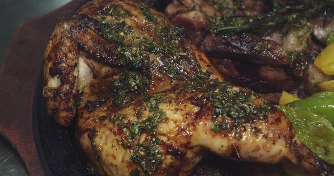 Beautiful slow motion shot of each meat, chicken, chorizo and potatoes of a Venezuelan grill plate inside a restaurant kitchen.