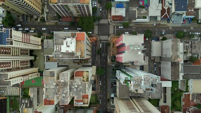 flying over big buildings: aerial view looking down to a busy road in the city centre of Londrina, Parana, Brazil