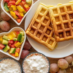 Belgian waffles served with vegetable salad, cottage cheese, fresh grapes for tasty breakfast.