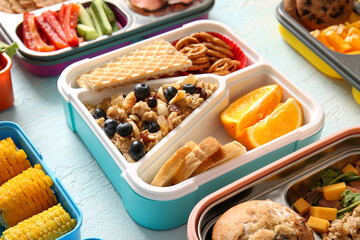 Lunchboxes with different delicious food on gradient background