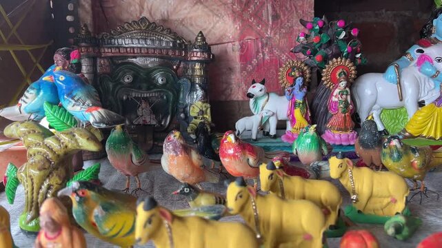 Clay idols or puppets in shape of Krishna and animals kept in pottery shop for Janmasthami celebration.