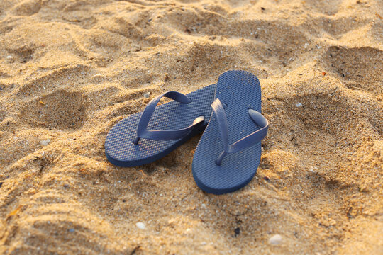 Stylish flips flops on sand at resort