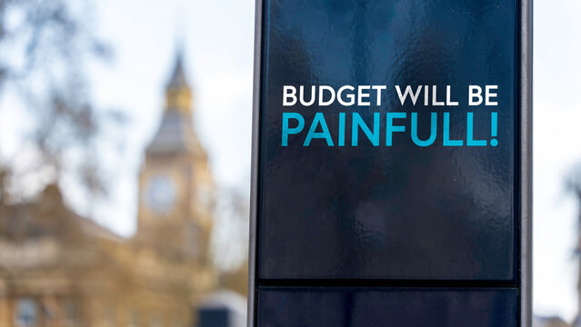 Budget will be painful sign in front of Westminster	
