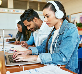 Laptop, music and typing with girl student in class at college or university for education and research. Computer, headphones and learning with scholar in school classroom for online assessment
