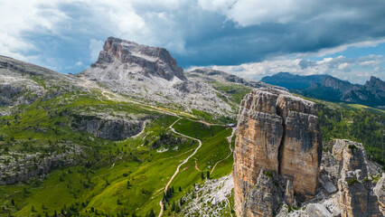 An aerial view of the incredible Cinque Torri mountains in the Dolomites, Italy, captured by a drone. This breathtaking shot showcases the dramatic rock formations and rugged beauty of  mountains