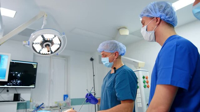 Neurosurgeon touches patient's head with the neurological probe. Advanced methods of neurosurgery in modern clinics. Low angle view.