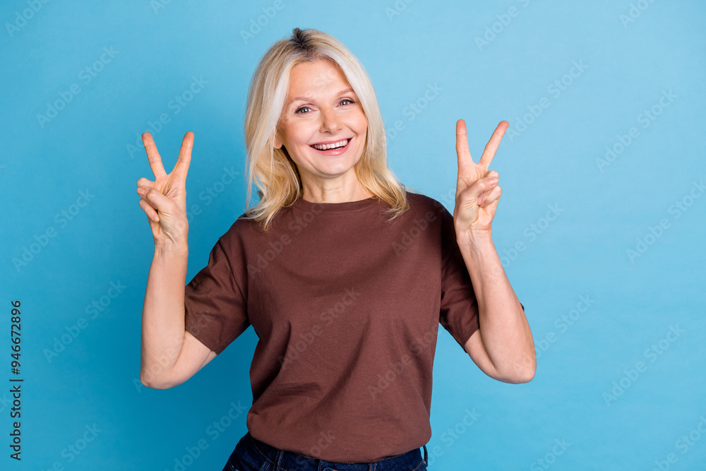 Wall mural photo of good mood nice senior woman wear stylish clothes demonstrate v-sign isolated on blue color 