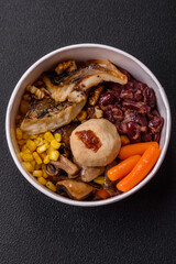 A colorful vegetarian dish consists of fish, beans, corn, mushrooms