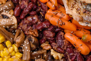 A colorful vegetarian dish consists of fish, beans, corn, mushrooms
