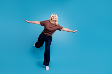 Fototapeta premium Photo of lovely nice senior woman wear stylish brown clothes have fun fly air isolated on blue color background