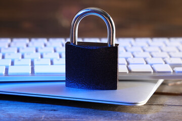 Padlock with laptop and computer keyboard on table, closeup. Cyber security concept