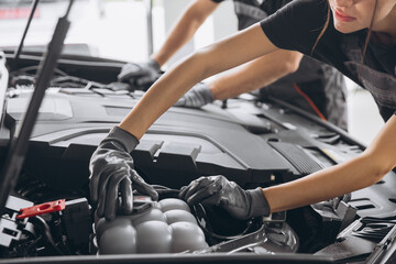 Trying to identify the source of the problem. Close-up shot of two mechanics man and woman working...