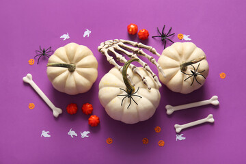 Composition with fresh pumpkins and decorations for Halloween on purple background