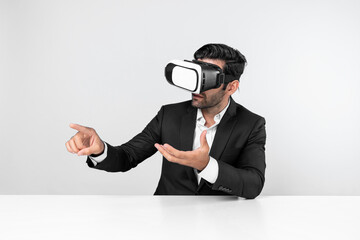 Smart businessman sitting while pointing and choosing data analysis by using technology innovation. Professional caucasian project manager using virtual reality glasses and VR goggles. Deviation.