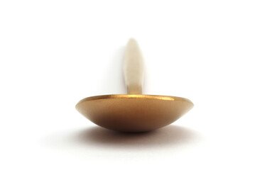 Close up Gold bronze spoon on white. Selective soft focus