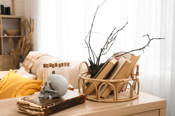 Books with skull and tree branches on commode in living room decorated for Halloween
