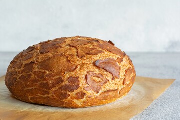Fresh crispy Tiger (Dutch) bread with a delicious beautiful crust and wonderful homemade taste on a light background. Bakery product with cracks.