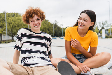 Cute happy smiling couple of teenagers classmates college students high school pupils have fun date...