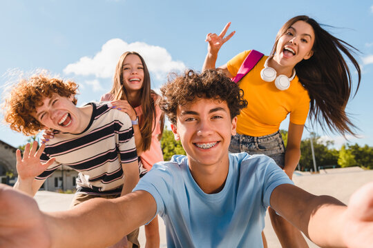 Selfie shot of crazy young people friends college students school pupils classmates teenagers having fun together spend time summer weekend in skate park outside urban street. Friendship concept