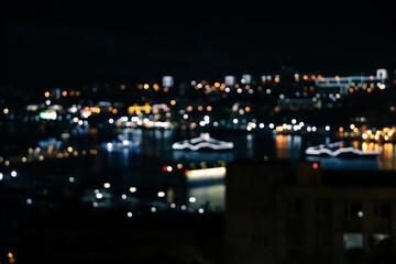 Defocused blurred night city view with lights on black background
