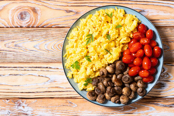 Homemade scrambled eggs with mushrooms and cherry tomatoes
