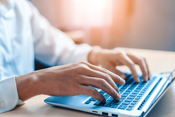 Businessman hand typing on computer keyboard of a laptop computer in office. Business and finance concept. uds