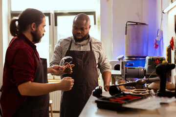 Master in woodworking shop giving BIPOC employee protection glasses before assembling furniture. Manufacturer preparing safety gear for african american apprentice before starting work