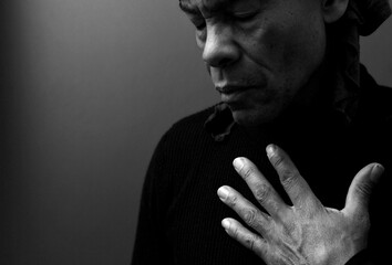 man praying to god with hands together Caribbean man praying on black background with people stock photos stock photo stock image	