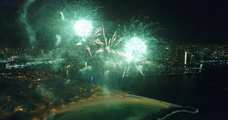 Cinematic drone shot of aerial fireworks going off on Honolulu beach