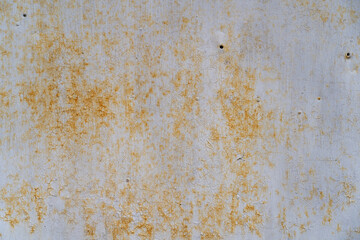 Grunge metal wall texture with peeling paint and yellow discoloration, indicating age and neglect over time