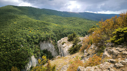 View of the high mountains banner with rocks on the foreground. Green mountain valley, beige stones, foggy mountains landscape, blue sky, freedom, nature, travel background, journey, meditation