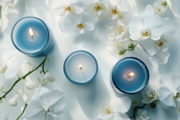 The white colored clean table surface with lazuli blue candles and white orchids flowers, top camera angle view, white mystique atmosphere, cinematic lighting