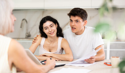 Fototapeta premium Insurance agent explaining conditions of insurance in home interior