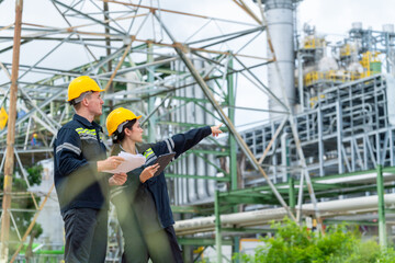 Man and woman petrochemical engineer teamwork meeting discussion at petroleum oil refinery industry area. Industrial factory technician worker working maintenance manufacturing energy power gas system