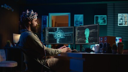 Developer with EEG headset on programming brain transfer into computer virtual world, becoming one...