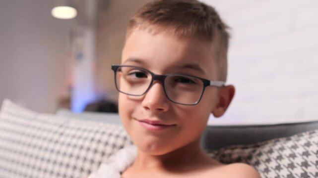 Portrait of a Young boy wearing ekg electrodes smiling at home, holter
