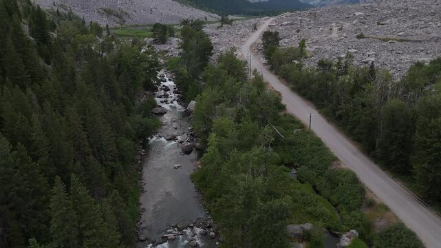 Aerial revealing shot flying over the Crowsnest River overlooking the Frank Slide avalanche disaster site.
