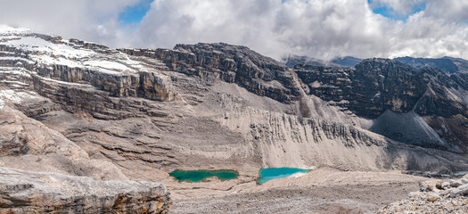 Panoramic of mountains with a glacial valley, beautiful white snow and a deep blue sky with clouds...