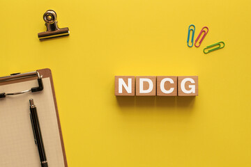 There is wood cube with the word NDCG. It is an abbreviation for Normalized Discounted Cumulative...
