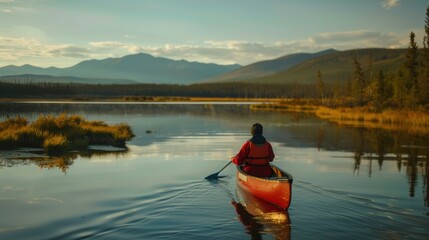 Adventurer canoeing across lake in wilderness during golden hour