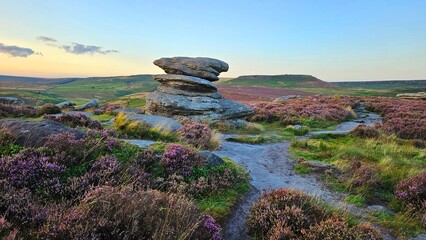 Stunning sunset over Hope Valley from Surprise View, showcasing Millstone Edge and Owler Tor, with vibrant heather in bloom creating a picturesque Peak District landscape.