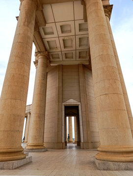 colonnade in the city, Huge stone pillars at the entrance to the Basilica of Our Lady of Peace in Yamoussoukro under a blue sky, Ivory Coast 01