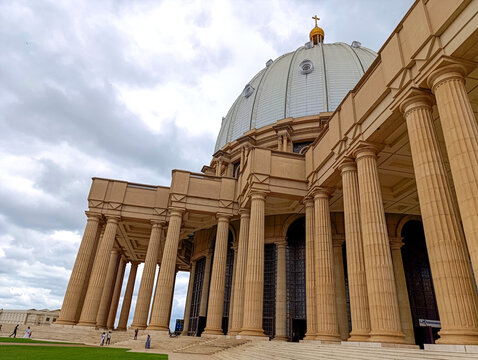 Huge stone pillars at the entrance to the Basilica of Our Lady of Peace in Yamoussoukro under a blue sky, Ivory Coast 01