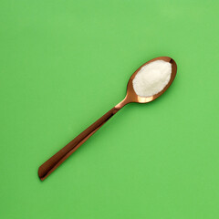 Baking Soda - Crystalline Solid compound in spoon. Green background