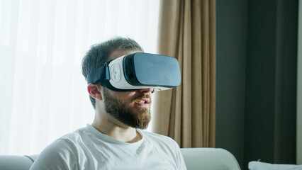 A man explores virtual reality with a VR headset, fully immersed in a digital experience....